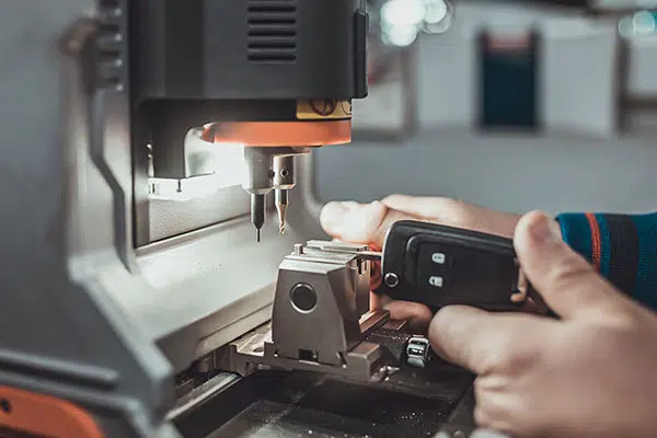 A car key replacement is made using a specialized machine.